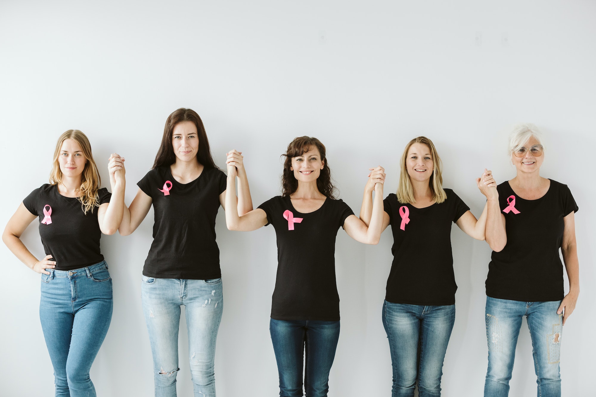 Five women in black tshirts and blue jeans standing together