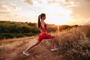 Young fit slim woman doing fitness in the park outdoors on the sunset. Sports and women health
